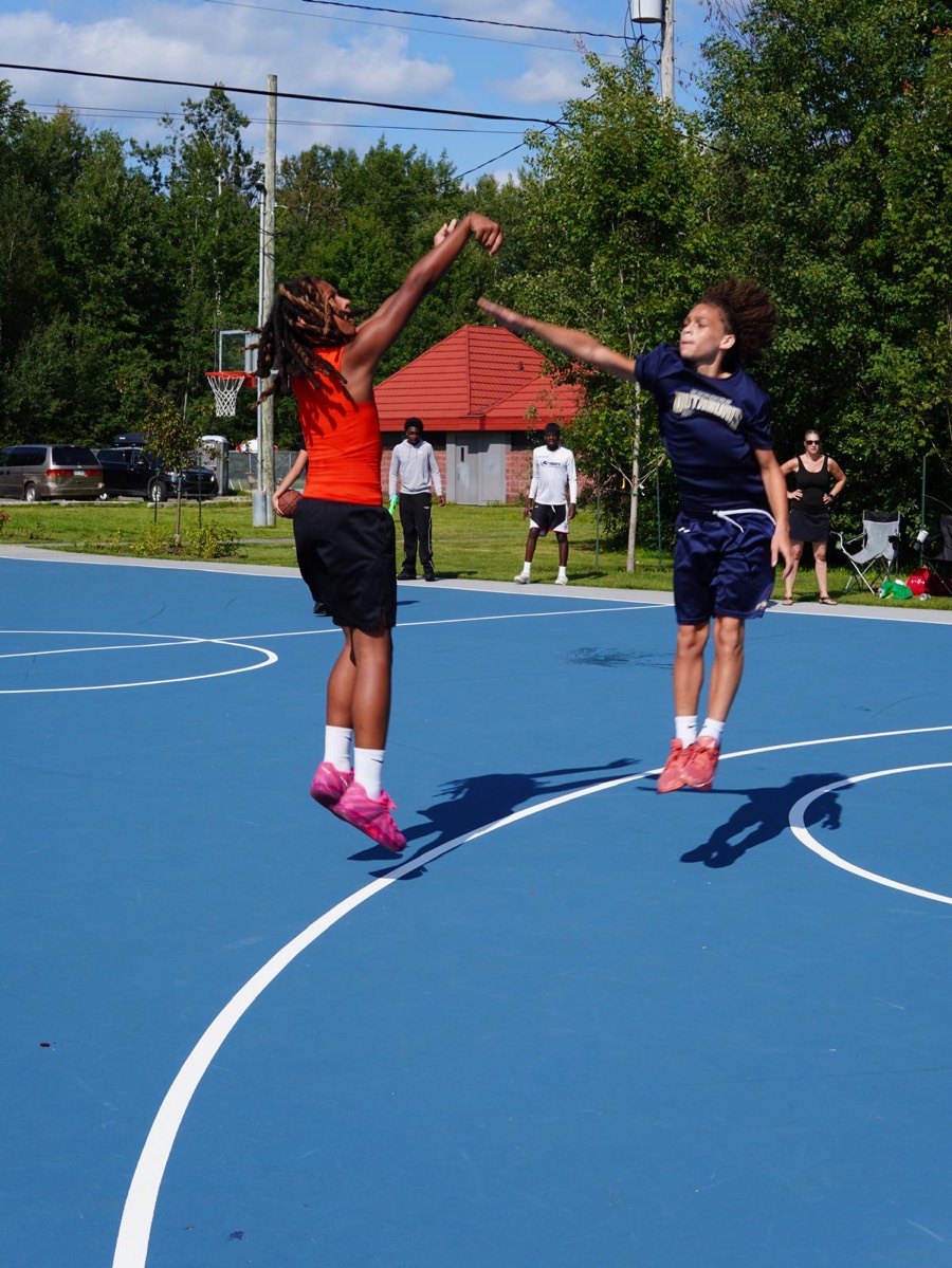 Players jumping for a shot during a game at the Check Up summer community event